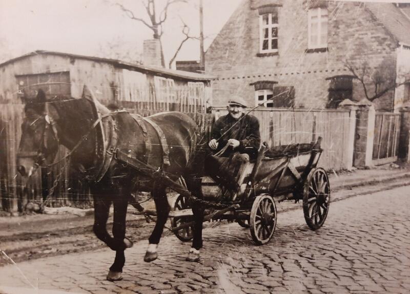 Pferdefuhrwerk auf der Dorfstraße, historische Aufnahme