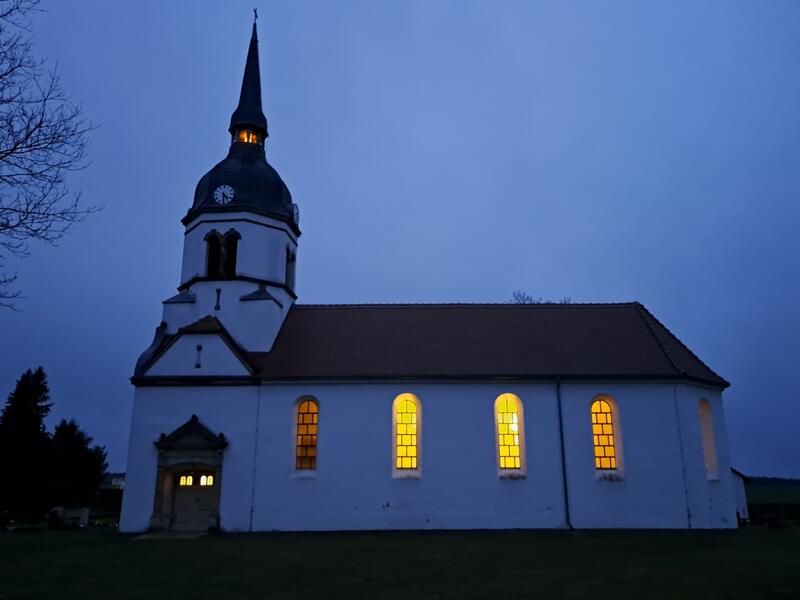 Erleuchtete Dorfkirche am Abend