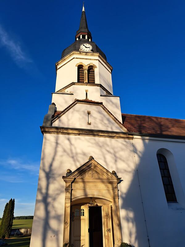 Kirchturm der Dorfkirche Schköna vor blauem Himmel