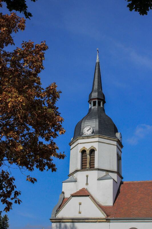 Kirchturm der Dorfkirche Schköna im Herbstlaub