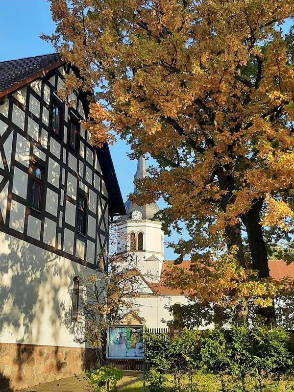 Fachwerk und Kirchturm im Herbstlaub