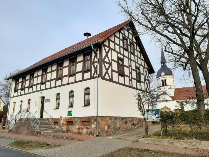 Fachwerkhaus mit Kirchturm im Hintergrund
