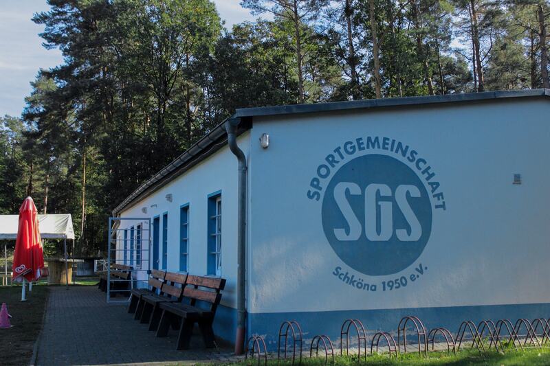 Sportlerheim der SG Schköna mit dem Vereinslogo an der Wand
