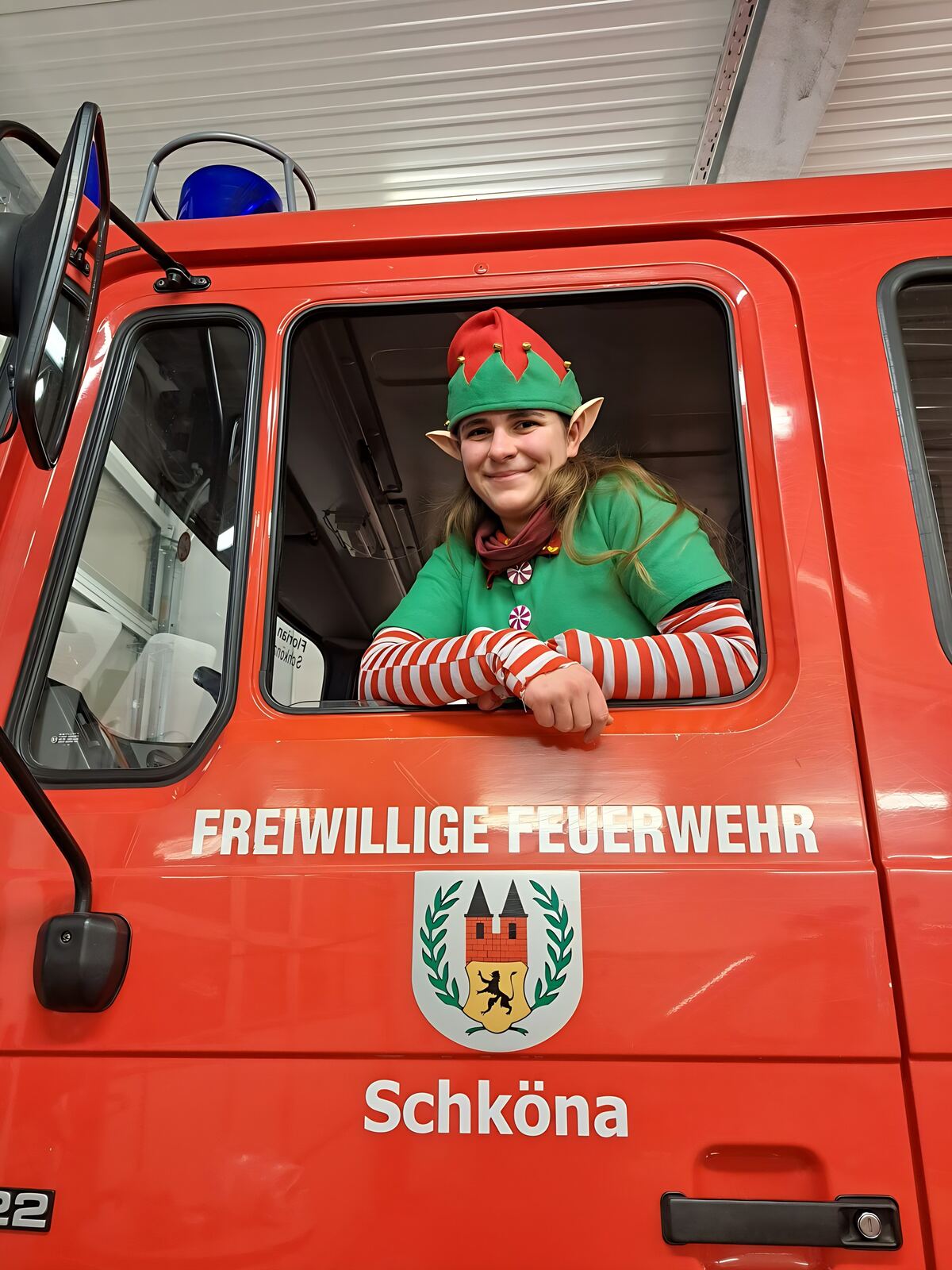 Weihnachtselfe schaut aus dem Fenster des Löschfahrzeugs der Freiwilligen Feuerwehr Schköna, Dezember 2024