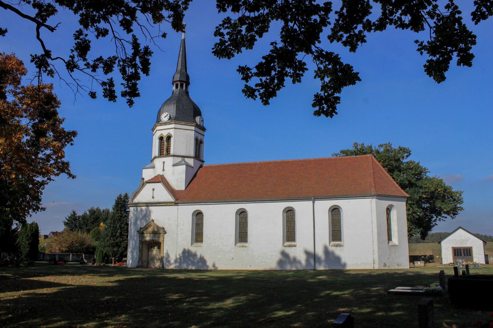 Dorfkirche Schköna, Gesamtansicht unter blauem Himmel, Oktober 2026